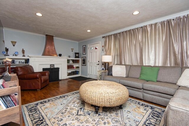 2344 E Manchester St, Springfield, MO 65804 - living room featuring wood finished floors, a large fireplace, crown molding, recessed lighting, and a textured ceiling