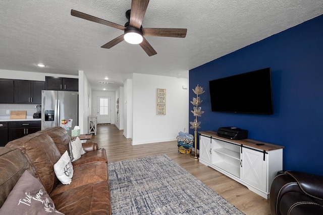 1118 E Lakota St, Nixa, MO 65714 - living area with a ceiling fan, light wood finished floors, a textured ceiling, baseboards, and recessed lighting
