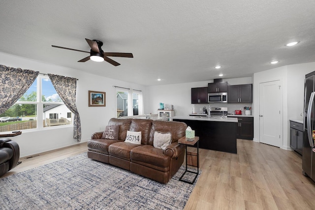 1118 E Lakota St, Nixa, MO 65714 - living area featuring light wood-style floors, a ceiling fan, recessed lighting, and a textured ceiling