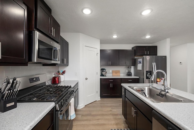 1118 E Lakota St, Nixa, MO 65714 - kitchen featuring stainless steel appliances, a sink, light wood-type flooring, light countertops, and decorative backsplash