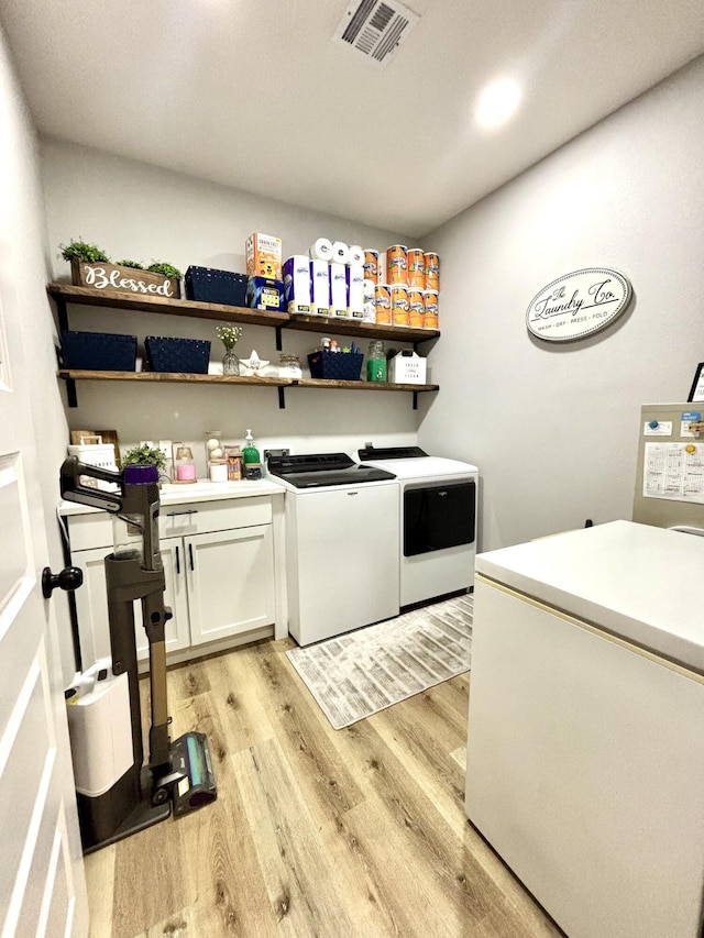 2702 Town Dr, Mountain Grove, MO 65711 - laundry area with independent washer and dryer, light wood-type flooring, and cabinet space