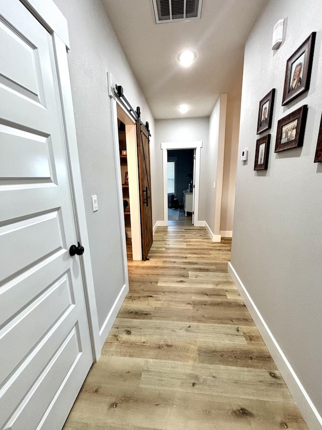 2702 Town Dr, Mountain Grove, MO 65711 - hallway with a barn door, light wood finished floors, and baseboards
