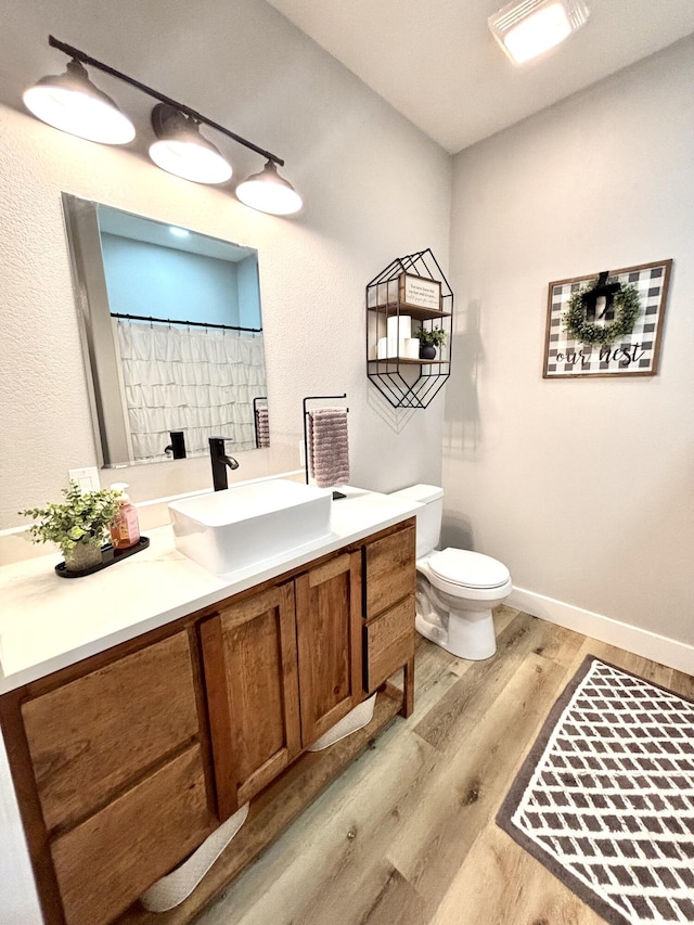 2702 Town Dr, Mountain Grove, MO 65711 - full bathroom with wood finished floors, vanity, toilet, curtained shower, and baseboards