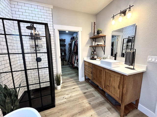 2702 Town Dr, Mountain Grove, MO 65711 - full bath with a shower stall, wood finished floors, vanity, baseboards, and a walk in closet