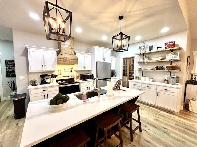2702 Town Dr, Mountain Grove, MO 65711 - kitchen with stainless steel appliances, a sink, a chandelier, custom exhaust hood, and white cabinets