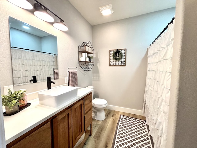 2702 Town Dr, Mountain Grove, MO 65711 - bathroom with wood finished floors, vanity, toilet, and baseboards