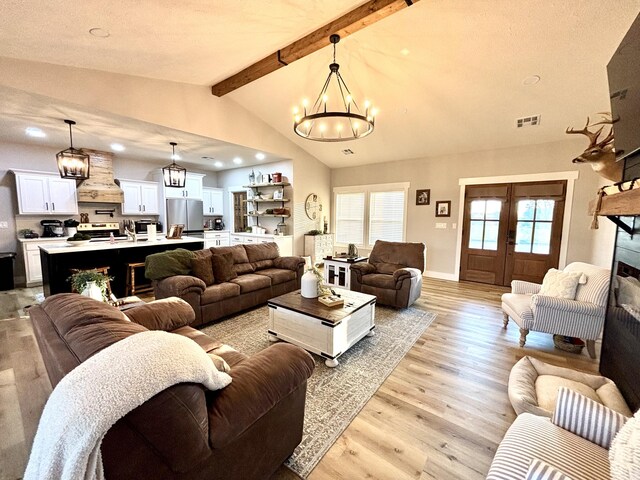 2702 Town Dr, Mountain Grove, MO 65711 - living room with a chandelier, light wood-style floors, a fireplace, recessed lighting, and french doors