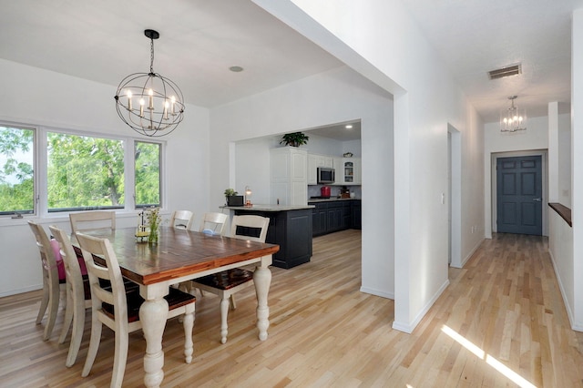 11976 N Northern Hts Dr, Brighton, MO 65617 - dining area with a chandelier, light wood-type flooring, and baseboards