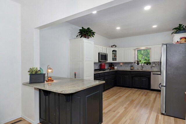 11976 N Northern Hts Dr, Brighton, MO 65617 - kitchen featuring stainless steel appliances, a peninsula, white cabinetry, light wood-type flooring, and recessed lighting