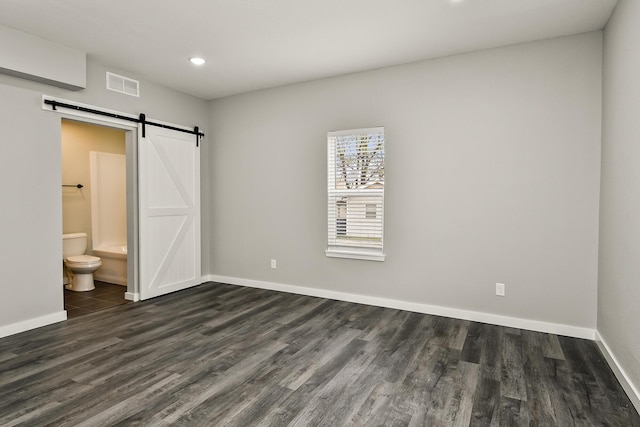 111 S Mill St, Rogersville, MO 65742 - unfurnished bedroom featuring a barn door, dark wood-style flooring, baseboards, and recessed lighting