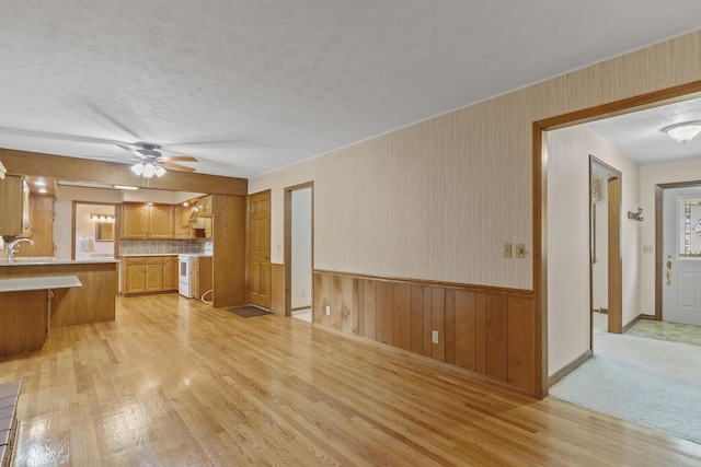 5263 N Crestwood Dr, Springfield, MO 65803 - kitchen featuring light wood-type flooring, white range, light countertops, ceiling fan, and wainscoting