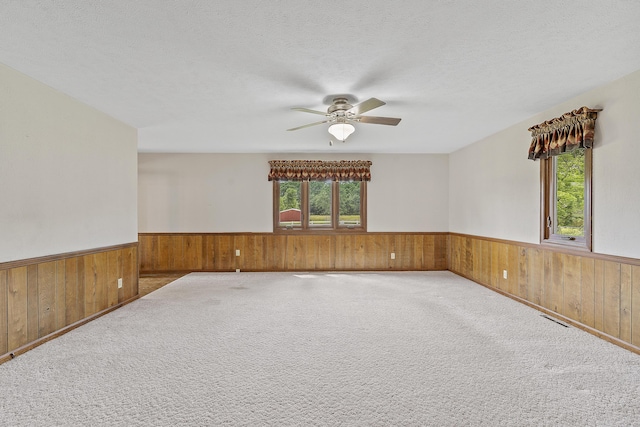 5263 N Crestwood Dr, Springfield, MO 65803 - carpeted empty room with wainscoting, wood walls, ceiling fan, and a textured ceiling