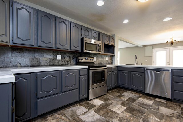 5364 Cloverdale Ln, Battlefield, MO 65619 - kitchen with appliances with stainless steel finishes, a sink, a chandelier, tasteful backsplash, and light countertops