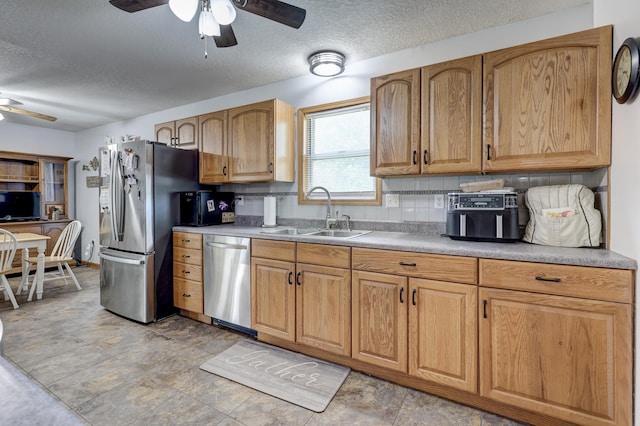 1631 Robertson Ave, Carthage, MO 64836 - kitchen with stainless steel appliances, a sink, ceiling fan, a textured ceiling, and decorative backsplash
