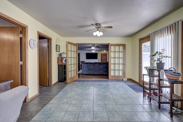 1631 Robertson Ave, Carthage, MO 64836 - tiled living area featuring a ceiling fan, a textured ceiling, french doors, and baseboards