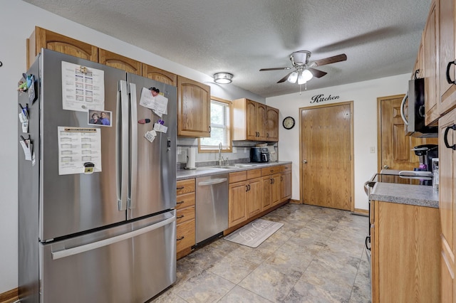 1631 Robertson Ave, Carthage, MO 64836 - kitchen featuring appliances with stainless steel finishes, a sink, ceiling fan, a textured ceiling, and light countertops