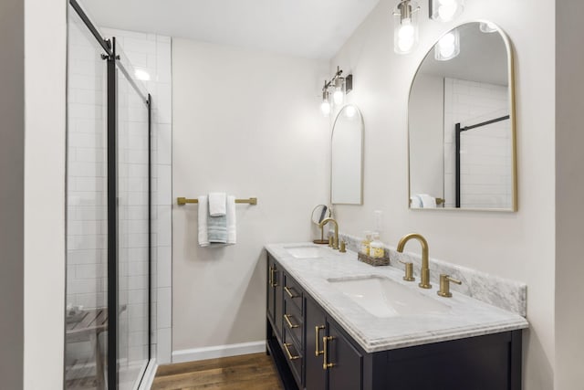 3050 Montague Ln, Kimberling City, MO 65686 - full bathroom with double vanity, wood finished floors, a tile shower, and baseboards