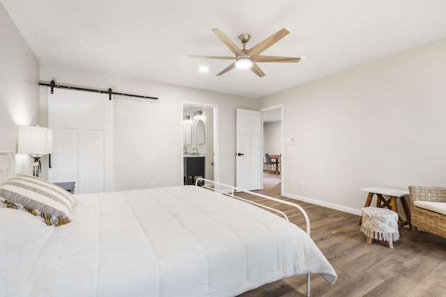 3050 Montague Ln, Kimberling City, MO 65686 - bedroom with a barn door, wood finished floors, baseboards, a ceiling fan, and a sink