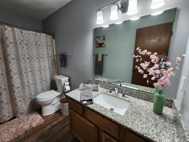 388 Notch Ln Unit 12, Branson West, MO 65737 - full bathroom with wood finished floors, toilet, vanity, a textured ceiling, and curtained shower