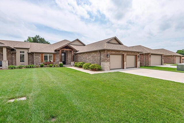 2370 E Cardinal St, Springfield, MO 65804 - view of front of house featuring a garage, a front yard, brick siding, driveway, and a shingled roof