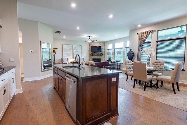 2370 E Cardinal St, Springfield, MO 65804 - kitchen with a sink, stainless steel dishwasher, dark countertops, a fireplace, and wood finished floors