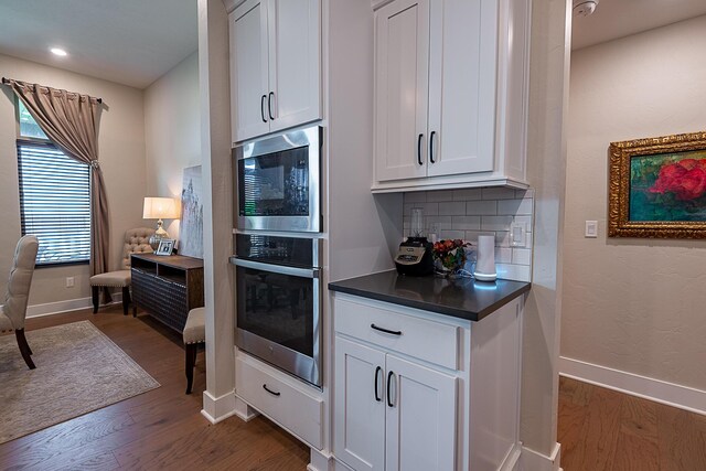 2370 E Cardinal St, Springfield, MO 65804 - kitchen featuring stainless steel appliances, dark wood-style floors, dark countertops, white cabinetry, and recessed lighting