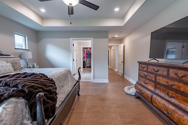 2370 E Cardinal St, Springfield, MO 65804 - bedroom featuring wood finished floors, baseboards, a walk in closet, a raised ceiling, and recessed lighting