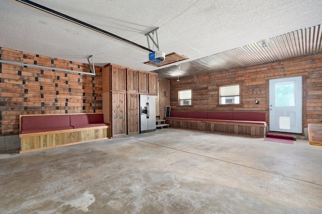 1132 Irene Ct, Nixa, MO 65714 - garage with wooden walls, a garage door opener, and fridge with ice dispenser