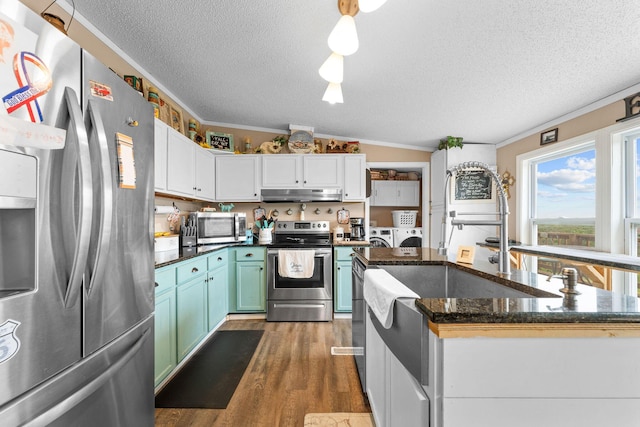28286 Clay Rd, Eagle Rock, MO 65641 - kitchen with appliances with stainless steel finishes, a textured ceiling, under cabinet range hood, washer and dryer, and ornamental molding