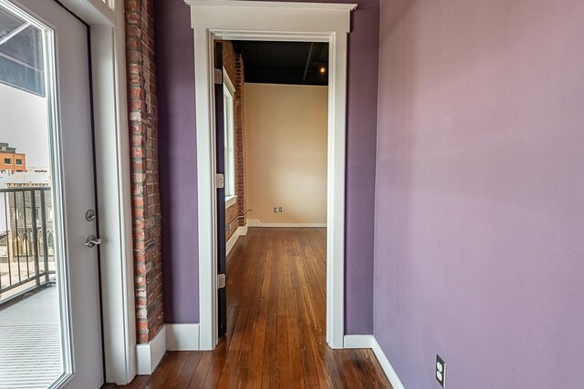 corridor featuring dark wood finished floors and baseboards