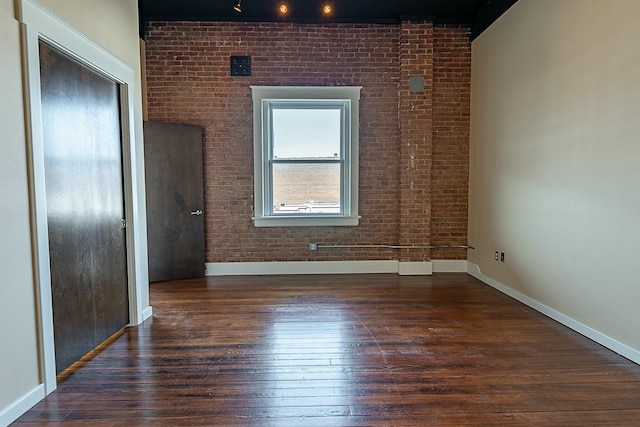 spare room featuring hardwood / wood-style floors and baseboards
