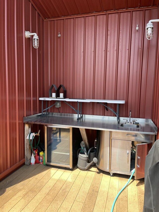 miscellaneous room with wood finished floors, beverage cooler, and wood walls