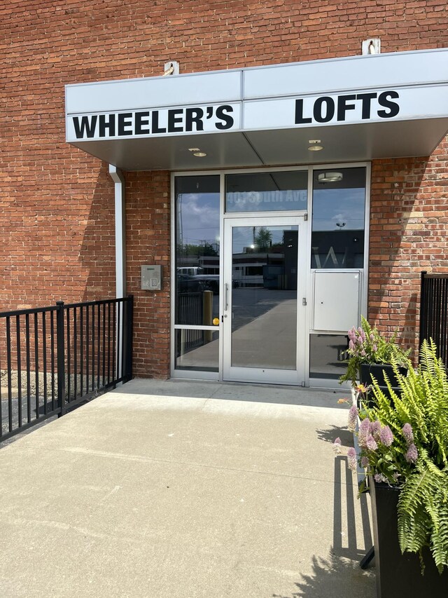 view of exterior entry featuring brick siding