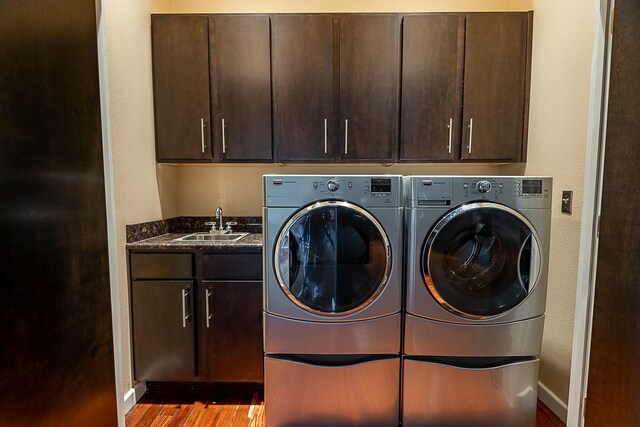 laundry area with cabinet space, washer and dryer, wood finished floors, and baseboards
