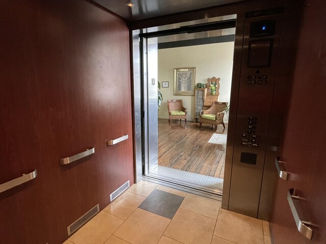 entryway with tile patterned flooring and elevator