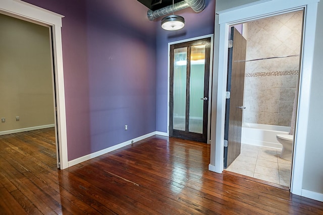 spare room with hardwood / wood-style floors and baseboards
