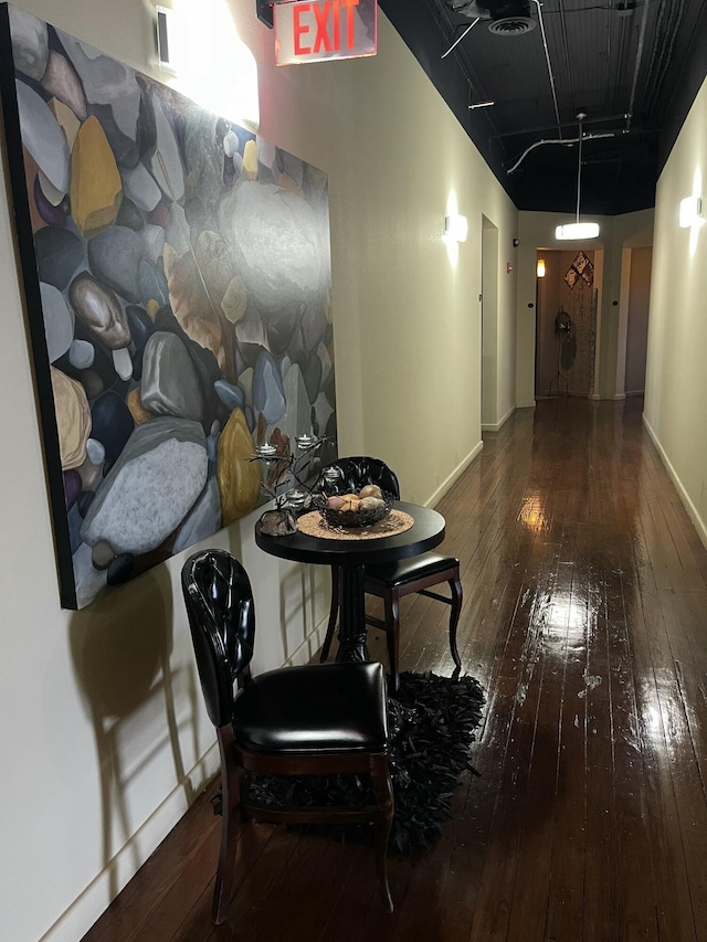 hallway featuring hardwood / wood-style floors and baseboards
