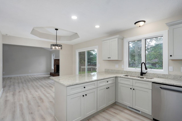 1436 W Whiteside St, Springfield, MO 65807 - kitchen featuring stainless steel dishwasher, a sink, a peninsula, a fireplace, and light wood-style flooring