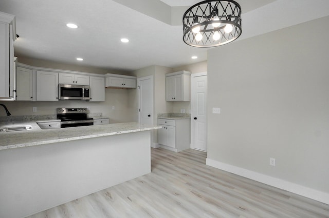 1436 W Whiteside St, Springfield, MO 65807 - kitchen featuring range with electric stovetop, stainless steel microwave, light wood-type flooring, a sink, and recessed lighting