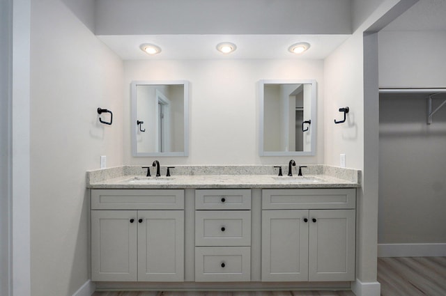 1436 W Whiteside St, Springfield, MO 65807 - bathroom featuring baseboards, double vanity, and wood finished floors