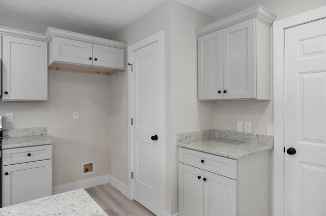 1436 W Whiteside St, Springfield, MO 65807 - kitchen featuring light wood-style floors, baseboards, light stone counters, and white cabinets