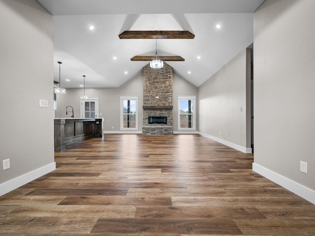 1691 S Charles Pl, Bolivar, MO 65613 - unfurnished living room featuring beamed ceiling, dark wood-type flooring, recessed lighting, a fireplace, and baseboards