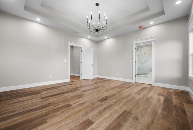 1691 S Charles Pl, Bolivar, MO 65613 - spare room featuring a raised ceiling, a chandelier, wood finished floors, recessed lighting, and baseboards