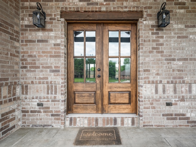 1691 S Charles Pl, Bolivar, MO 65613 - doorway to property featuring french doors, brick siding, and uncovered parking