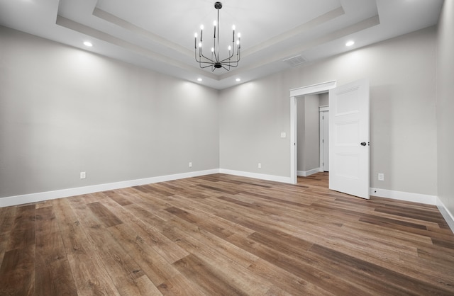 1691 S Charles Pl, Bolivar, MO 65613 - spare room with a tray ceiling, recessed lighting, a chandelier, wood finished floors, and baseboards