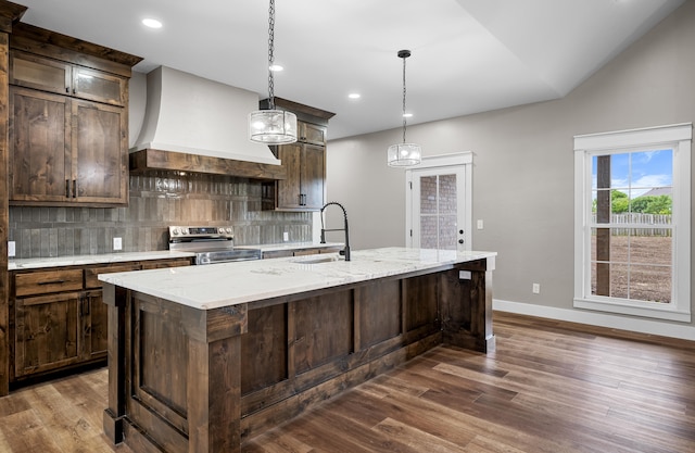 1691 S Charles Pl, Bolivar, MO 65613 - kitchen featuring stainless steel range with electric stovetop, a sink, decorative backsplash, a kitchen island with sink, and dark wood-style flooring