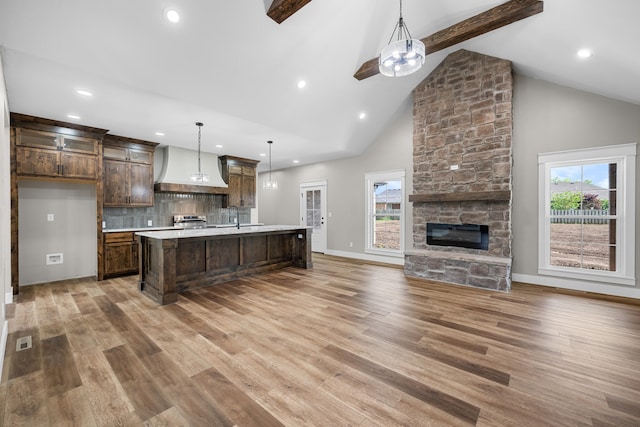 1691 S Charles Pl, Bolivar, MO 65613 - kitchen featuring custom exhaust hood, open floor plan, light countertops, stainless steel stove, and dark brown cabinetry