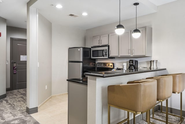 2204A Branson Landing Blvd, Branson, MO 65616 - kitchen featuring appliances with stainless steel finishes, a peninsula, dark countertops, a breakfast bar, and hanging light fixtures
