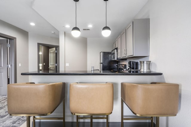 2204A Branson Landing Blvd, Branson, MO 65616 - kitchen featuring stainless steel microwave, recessed lighting, a peninsula, freestanding refrigerator, and dark countertops