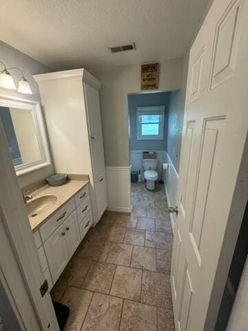 9153 N Hwy Highway, Mountain Grove, MO 65711 - bathroom with stone tile flooring, vanity, a textured ceiling, toilet, and baseboards